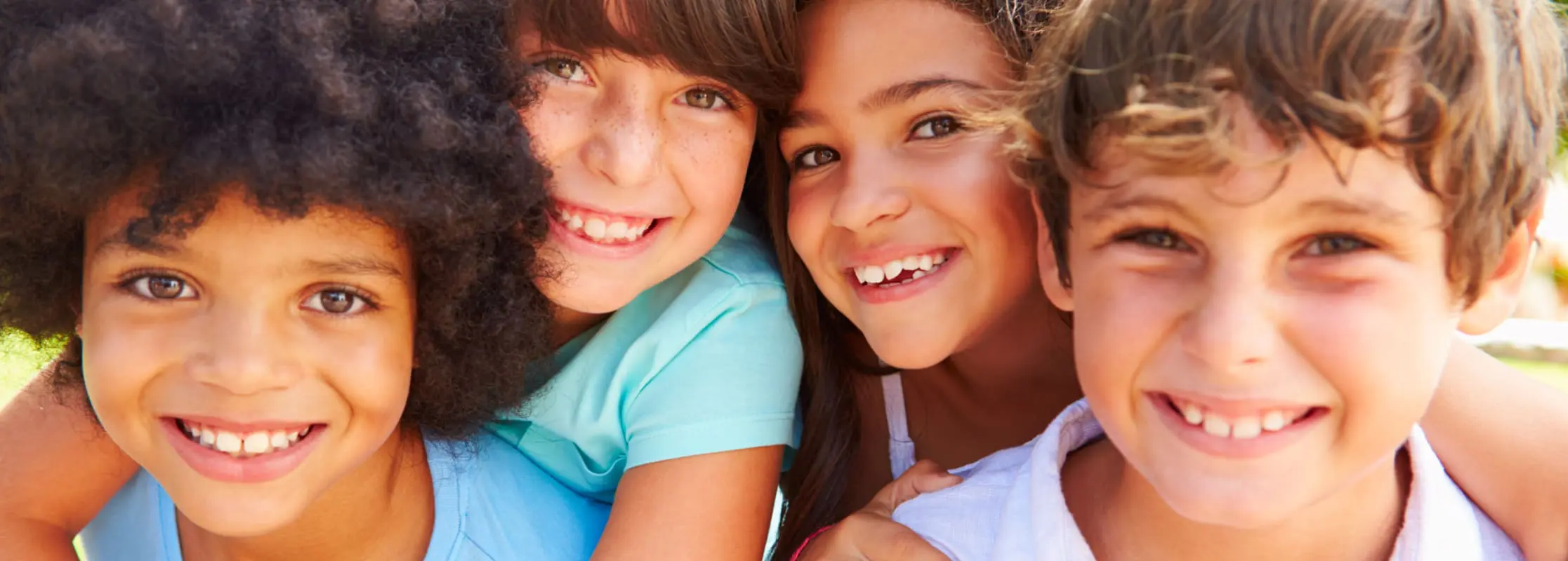 Group of young children smiling outdoors